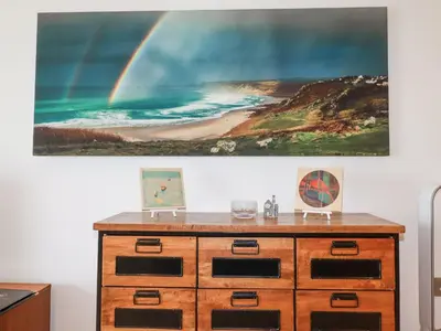 a painting of a rainbow above a wooden dresser at The Trick in St Ives