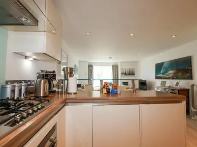a kitchen with white cabinets and a stove top oven at The Trick in St Ives