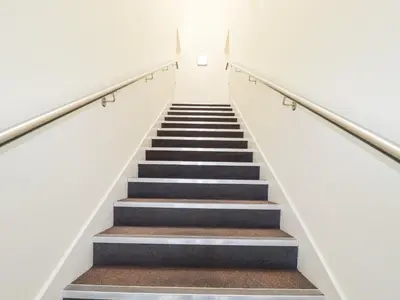 a staircase in a building with white walls and black stairs at The Trick in St Ives