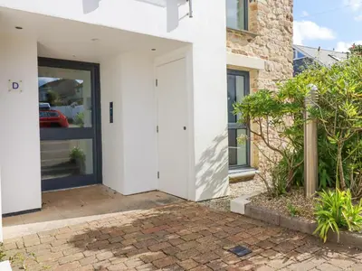 a pivot door in a white house with a courtyard at The Trick in St Ives