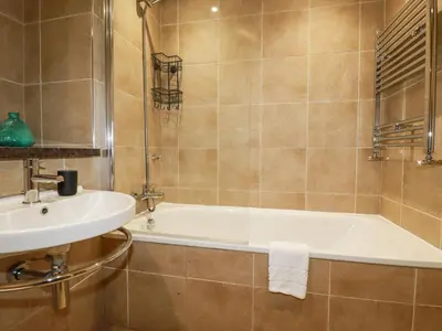 a bathroom with a bath tub and a sink at The Trick in St Ives