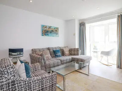 a living room with two couches and a glass table at The Trick in St Ives
