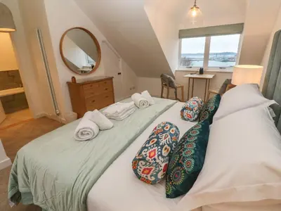 a bedroom with a large bed with two pillows at Fal View in Falmouth