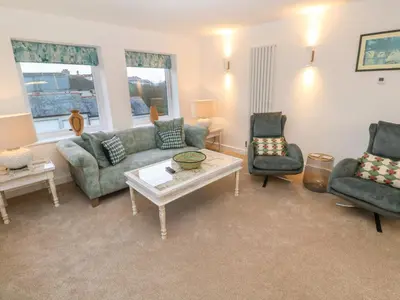 a living room with a couch and two chairs and a table at Fal View in Falmouth