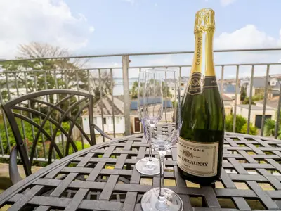 a bottle of champagne and two glasses on a table at Fal View in Falmouth