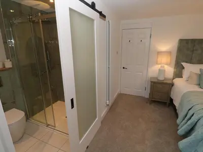 a bedroom with a shower and a bed and a bathroom at Fal View in Falmouth
