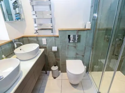 a bathroom with two sinks and a toilet and a shower at Fal View in Falmouth