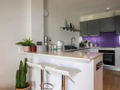 a kitchen with a white counter and purple cabinets at Fistral Tide in Newquay