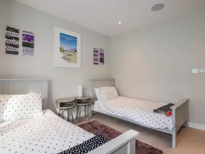 a room with two beds and a table and chairs at Fistral Tide in Newquay