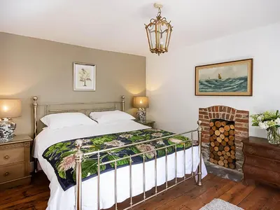 a bedroom with a bed and a fireplace at Number One in Mevagissey