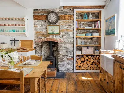 a living room with a table and a fireplace at Number One in Mevagissey