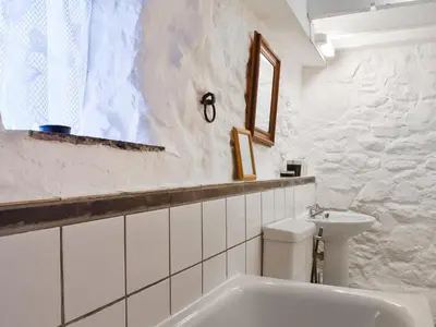 a white bathroom with a sink and a toilet at Scrumpy Cottage in Bodmin