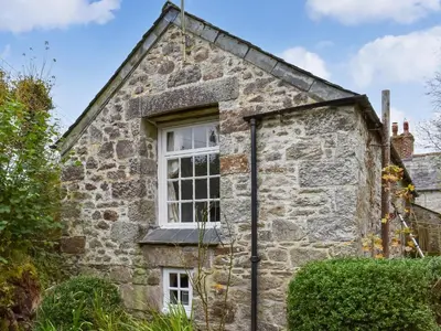 an old stone house with a window on the side at Scrumpy Cottage in Bodmin