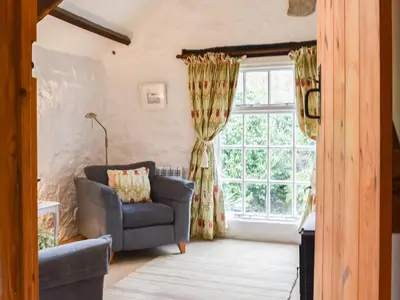 a living room with a couch and a window at Scrumpy Cottage in Bodmin