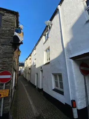 a street with a white building and a street sign at Guillemot Holiday Flat in Looe