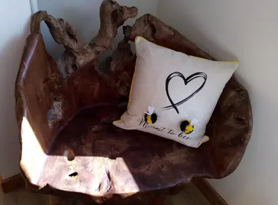 a pillow with a heart and two bees on it at Gunnado in St Austell