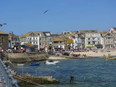 a group of buildings and a beach with boats in the water at Gunnado in St Austell