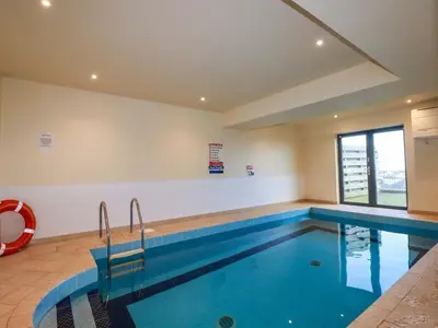 a large swimming pool in a building with a large window at Apartment 3 in Newquay