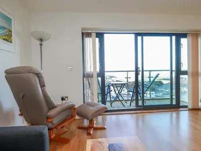 a living room with a chair and a window at Apartment 3 in Newquay
