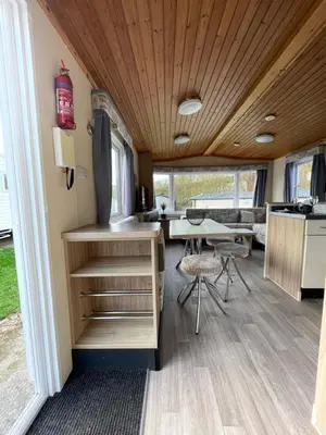 a kitchen and dining area of a tiny house at Newquay Bay Holiday Resort Caravan 73 in Porth
