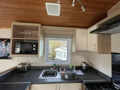a kitchen with a sink and a window at Newquay Bay Holiday Resort Caravan 73 in Porth