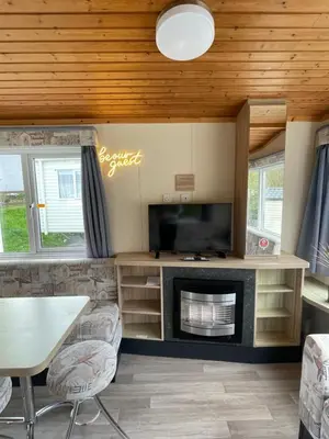 a living room with a fireplace and a tv at Newquay Bay Holiday Resort Caravan 73 in Porth