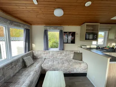 a living room with a couch and a table at Newquay Bay Holiday Resort Caravan 73 in Porth