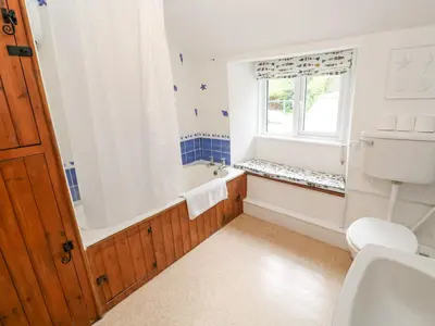 a bathroom with a tub and a toilet and a sink at Penhaven in Helston