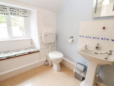 a white bathroom with a toilet and a sink at Penhaven in Helston