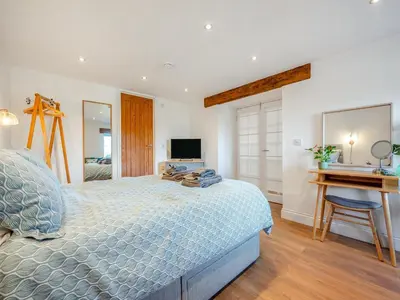 a bedroom with a bed and a desk and a television at Horseshoe Cottage - Uk48252 in Downderry