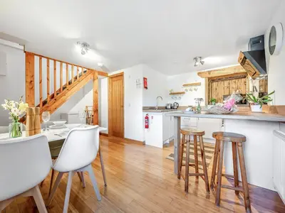 a kitchen with a counter and stools in a room at Roosters Rest - Uk48255 in Downderry