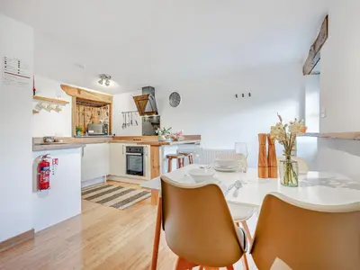 a kitchen and dining room with a white table and chairs at Roosters Rest - Uk48255 in Downderry