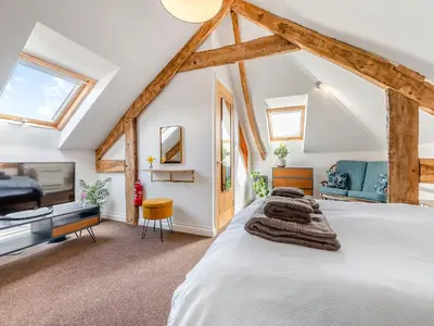a bedroom with a white bed and a tv at Roosters Rest - Uk48255 in Downderry