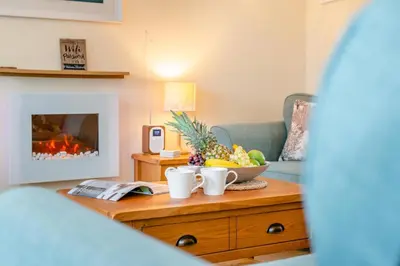 a living room with a table with a bowl of fruit at 2 Bed in Padstow oc-t30052 in Padstow