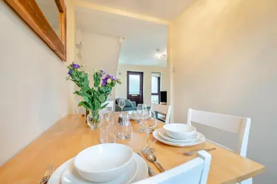 a dining room table with plates and glasses and flowers at 2 Bed in Padstow oc-t30052 in Padstow