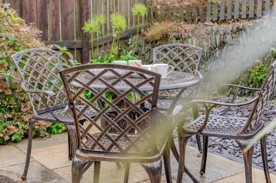 a patio table with two chairs and a fountain at 2 Bed in Padstow oc-t30052 in Padstow