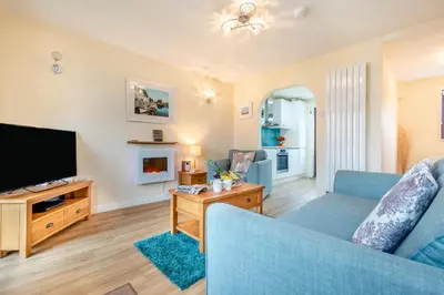 a living room with a blue couch and a tv at 2 Bed in Padstow oc-t30052 in Padstow
