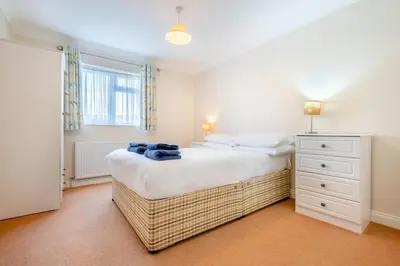 a bedroom with a bed and a dresser and a window at 3 Bed in St. Merryn oc-r30137 in St Merryn