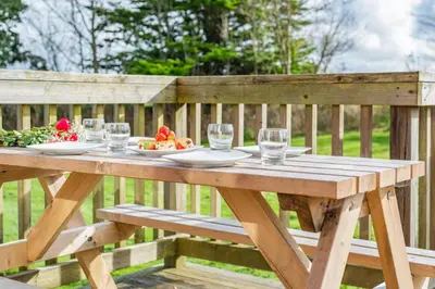 a wooden picnic table with a plate of food on it at 3 Bed in St. Merryn oc-r30137 in St Merryn