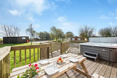 a wooden deck with a picnic table and a grill at 3 Bed in St. Merryn oc-r30137 in St Merryn