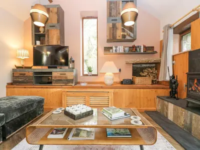 a living room with a coffee table and a fireplace at Harvey's House in Helston
