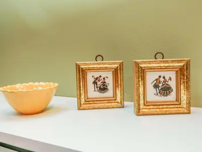 three framed pictures on a table with a bowl at Harvey's House in Helston