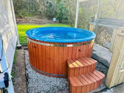 a large wooden tub with two benches around it at Harvey's House in Helston