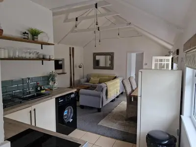 a kitchen and a living room with a couch at Trenant Cottage in Fowey