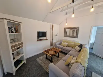 a living room with a couch and a table at Trenant Cottage in Fowey