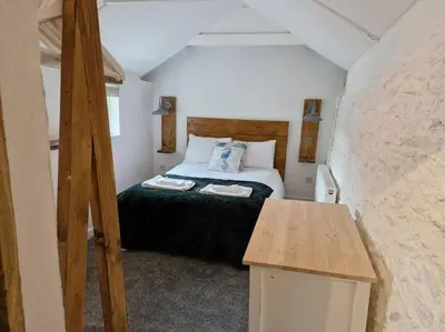 a bedroom with a bed in a small room at Trenant Cottage in Fowey