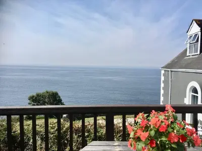 a view of the ocean from the balcony of a house at Wildly Romantic Cliff Top Apartment in Porthleven