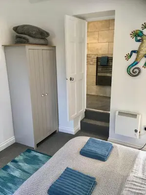 a room with two blue mats on a bed with a shower at Wildly Romantic Cliff Top Apartment in Porthleven