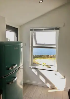 a kitchen with a green refrigerator and a window at Wildly Romantic Cliff Top Apartment in Porthleven