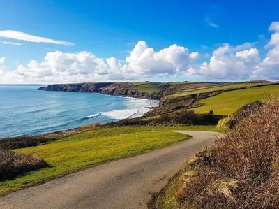 a dirt road next to a beach with the ocean at Wildly Romantic Cliff Top Apartment in Porthleven